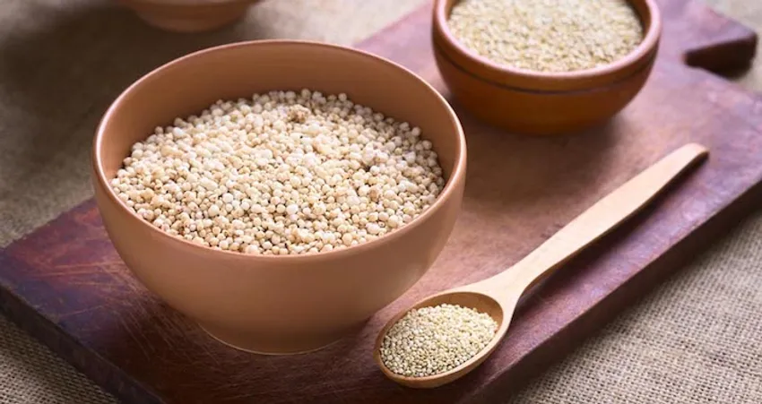 Bio Quinoa in Holzschalen - hochwertiges glutenfreies Superfood Helle Quinoa-Körner in rustikalen Holzschalen auf natürlichem Holzhintergrund